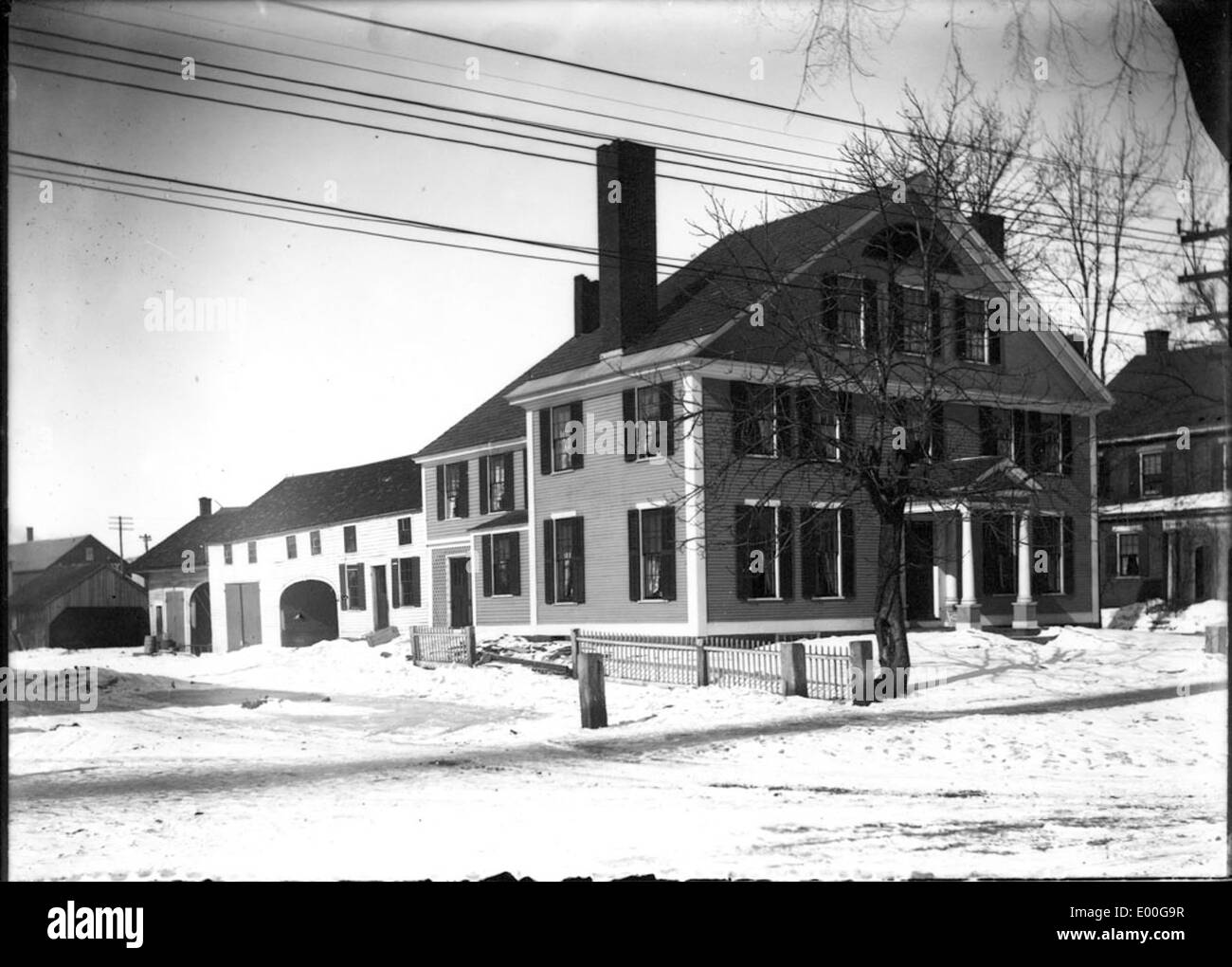 Une photographie d'une maison classique de 3 étages et d'une maison de transport adjacente, mettant en valeur un design architectural traditionnel avec un extérieur bien entretenu. Banque D'Images
