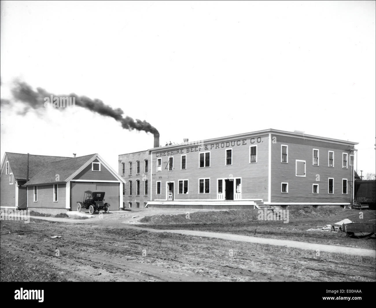 La Cheshire Beef & Produce Company, située sur Emerald Street à Keene, New Hampshire, est une entreprise locale réputée pour ses produits agricoles. Cette image montre son entrepôt avec une cheminée importante, représentant l’économie agricole historique de la région. Banque D'Images