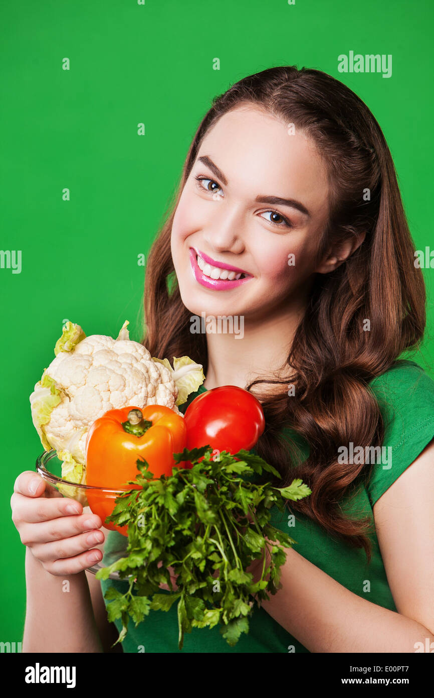 Belle femme avec un sac en papier de légumes. sur fond vert. Banque D'Images