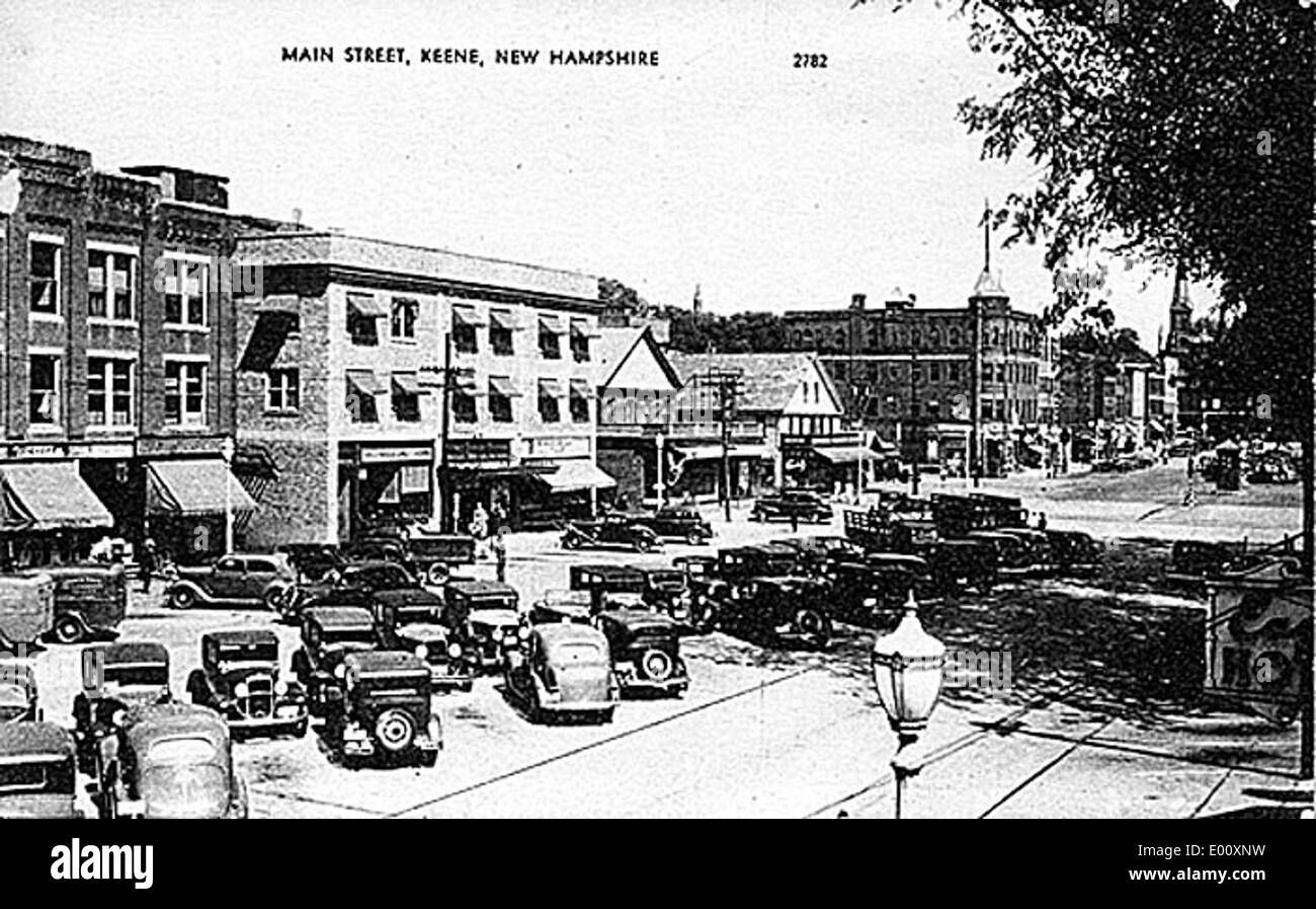 Cette photographie des années 1930 de main Street, West Side, Keene, New Hampshire, offre un aperçu du quartier des affaires de la ville, mettant en valeur les bâtiments historiques, les automobiles et la nature animée du centre-ville. Banque D'Images