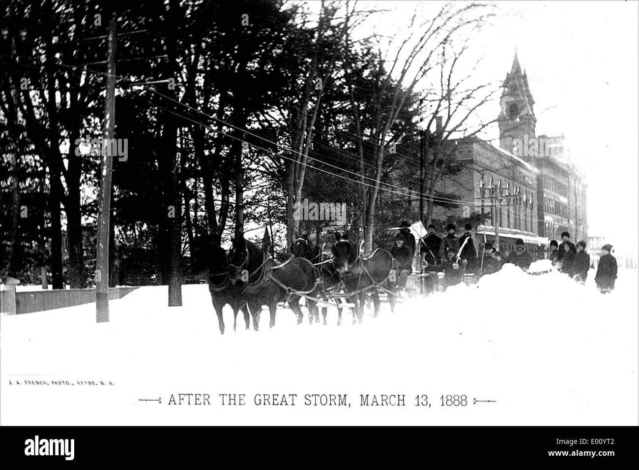 Une équipe de quatre chevaux lutte pour nettoyer les déneigements à Keene, dans le New Hampshire, pendant le Blizzard historique de 1888. Cette tempête de neige intense a causé des perturbations importantes dans le nord-est des États-Unis, et des équipes tirées par des chevaux ont souvent été utilisées pour briser la neige dans les zones urbaines. Banque D'Images