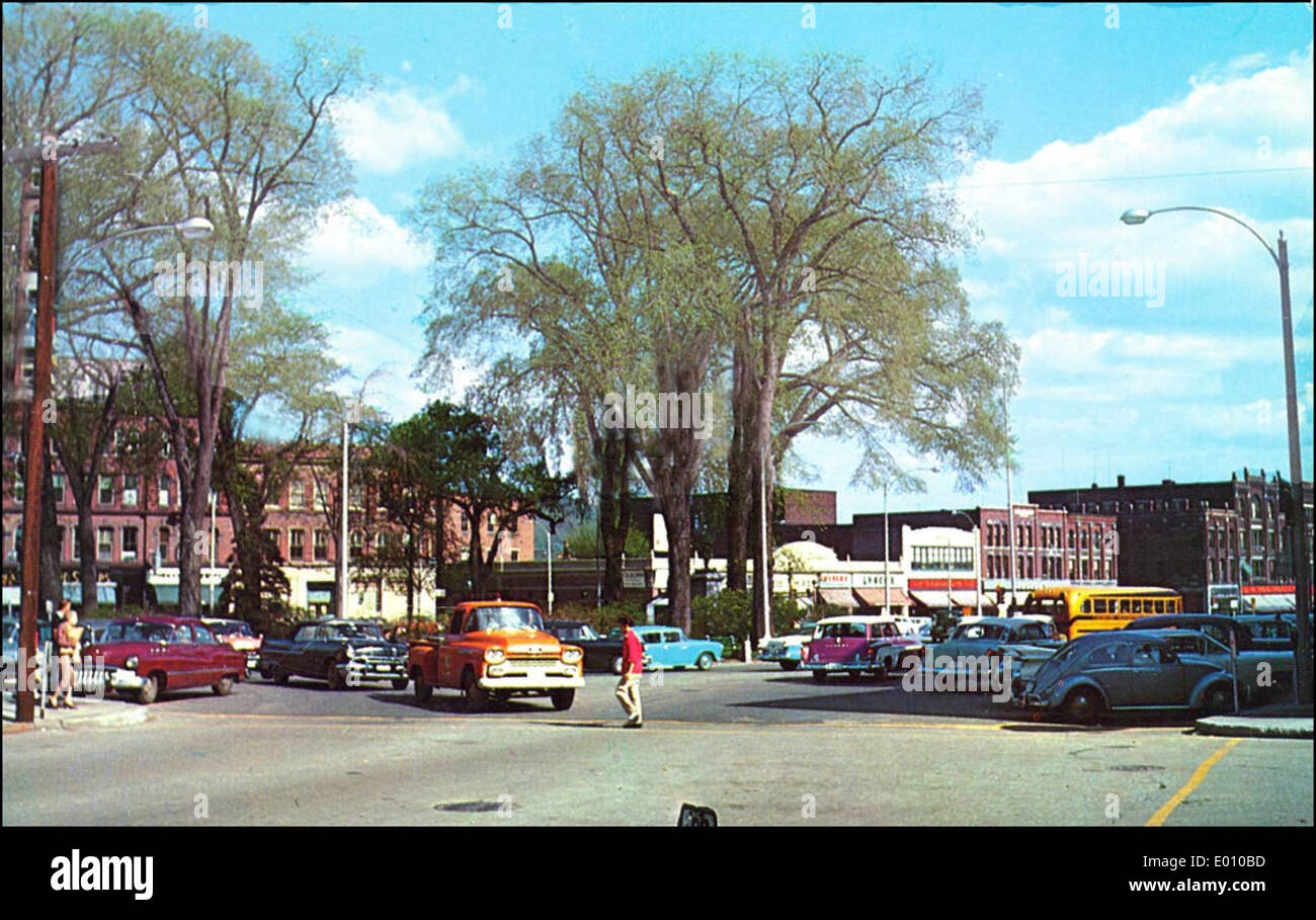 Central Square à Keene, dans le New Hampshire, capture un instantané du quartier des affaires de la ville, avec des voitures anciennes et des bâtiments historiques. Cette scène reflète le centre-ville de Keene, mettant en valeur son patrimoine commercial et son charme avec son atmosphère vintage. Banque D'Images