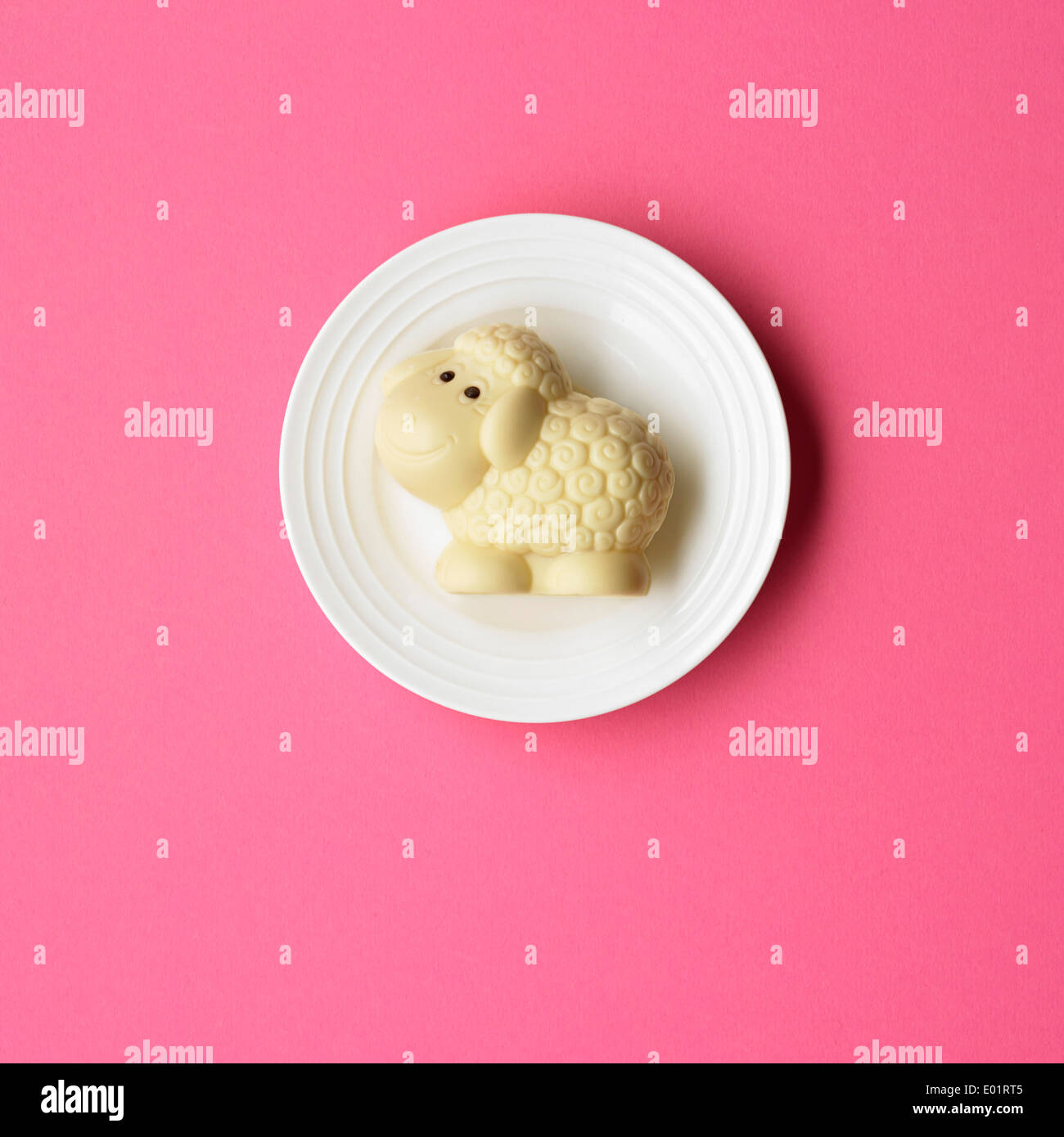Chocolat agneau sur petite plaque blanche sur fond rose Banque D'Images