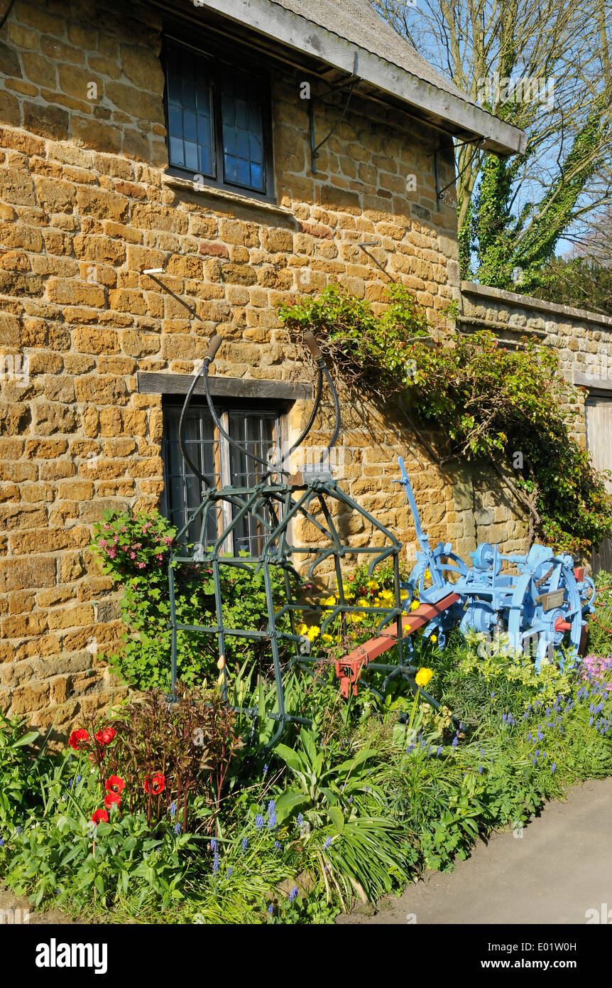 Faites glisser Harrow et pommes de terre Harvester contre mur Maison Ironstone Banque D'Images