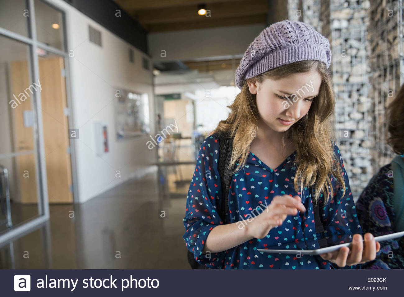 School girl using digital tablet in corridor Banque D'Images