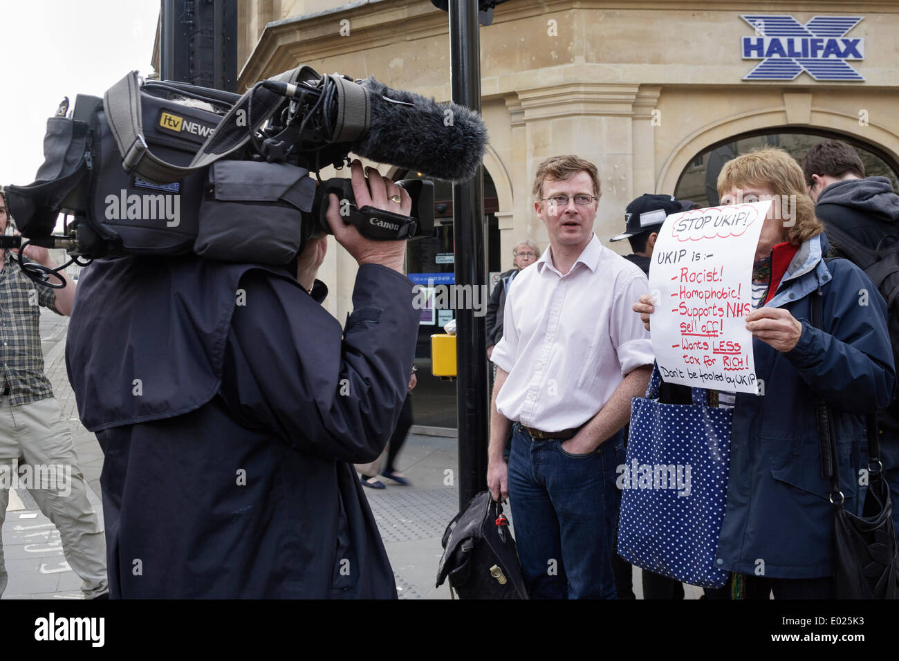 BATH, Royaume-Uni, le 29 avril, 2014. Une femelle de l'UKIP anti manifestant est filmé par une équipe de télévision alors qu'elle est titulaire d'une plaque à l'extérieur de l'UKIP anti Forum en baignoire,Nigel Farage le chef du parti indépendantiste du Royaume-Uni était due à prendre la parole lors de la réunion publique. Credit : lynchpics/Alamy Live News Banque D'Images