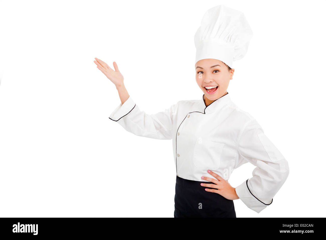 Jeune femme cuisinière lever les mains pour montrer quelque chose Banque D'Images