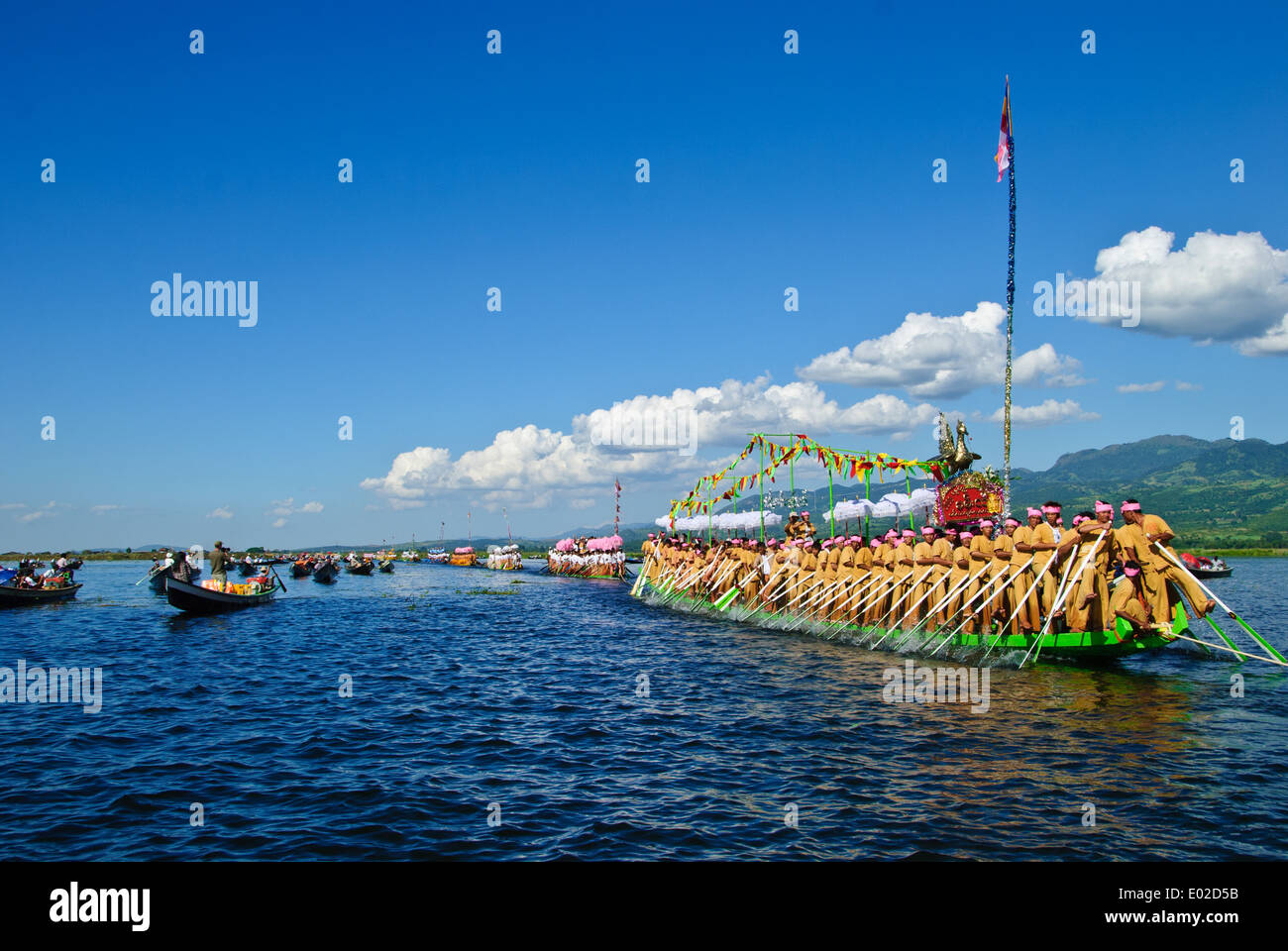 Leg-rameurs d'avancer en tirant sur la barge royale à travers le lac Inle pendant le festival Banque D'Images