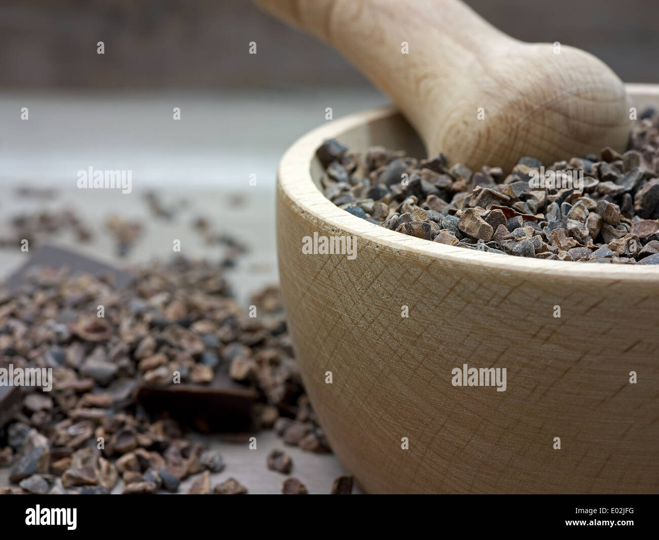 Nibs de cacao dans un pilon en bois Banque D'Images