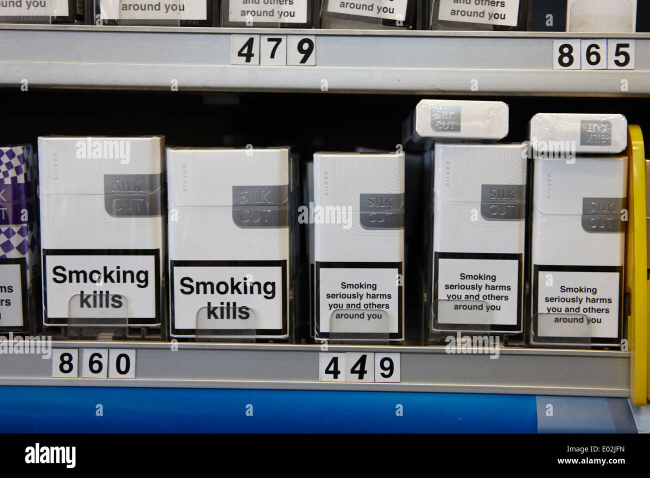 Les marques de cigarettes dans un emballage avec des avertissements pour la santé au cabinet dans un petit magasin d'Irlande Banque D'Images