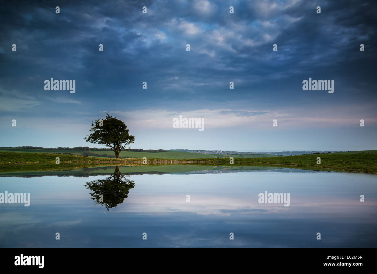 Moody ciel orageux reflète dans l'étang de rosée paysage de campagne Banque D'Images