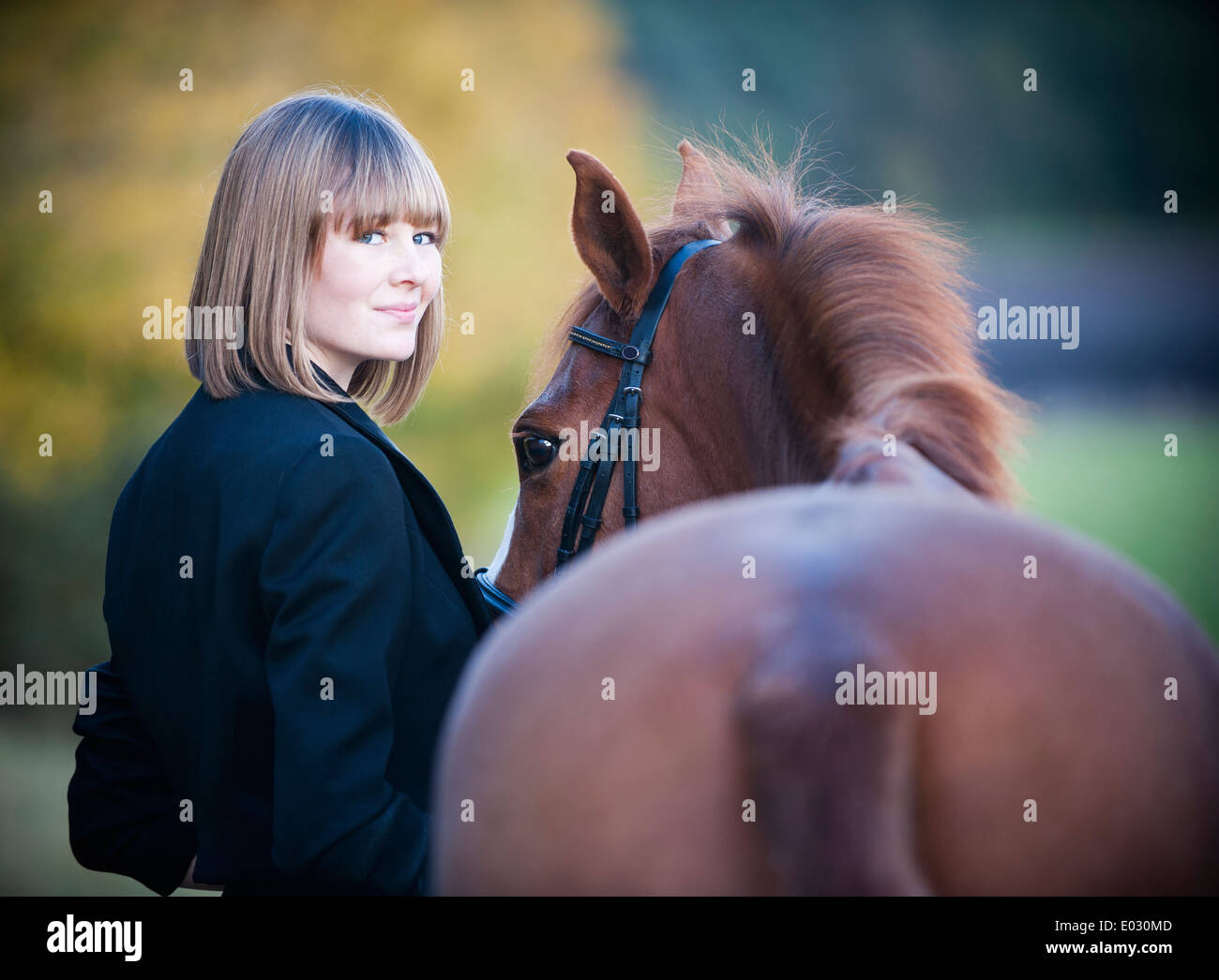 Une femme à la tête d'un cheval baie par la bride. Banque D'Images