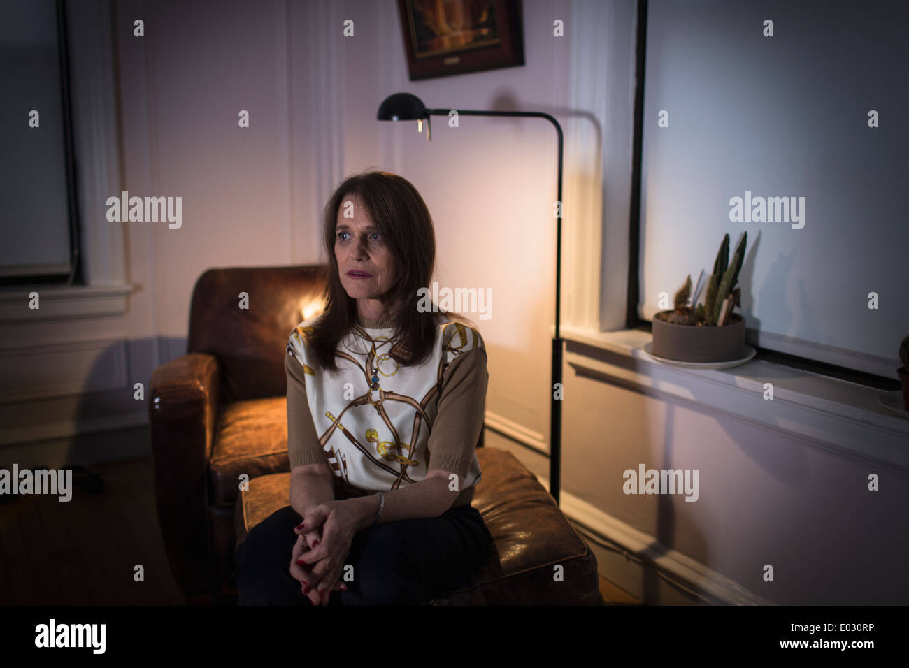Une femme d'âge moyen assis avec une expression triste. Banque D'Images Une femme d'âge moyen assis avec une expression triste. Banque D'Images