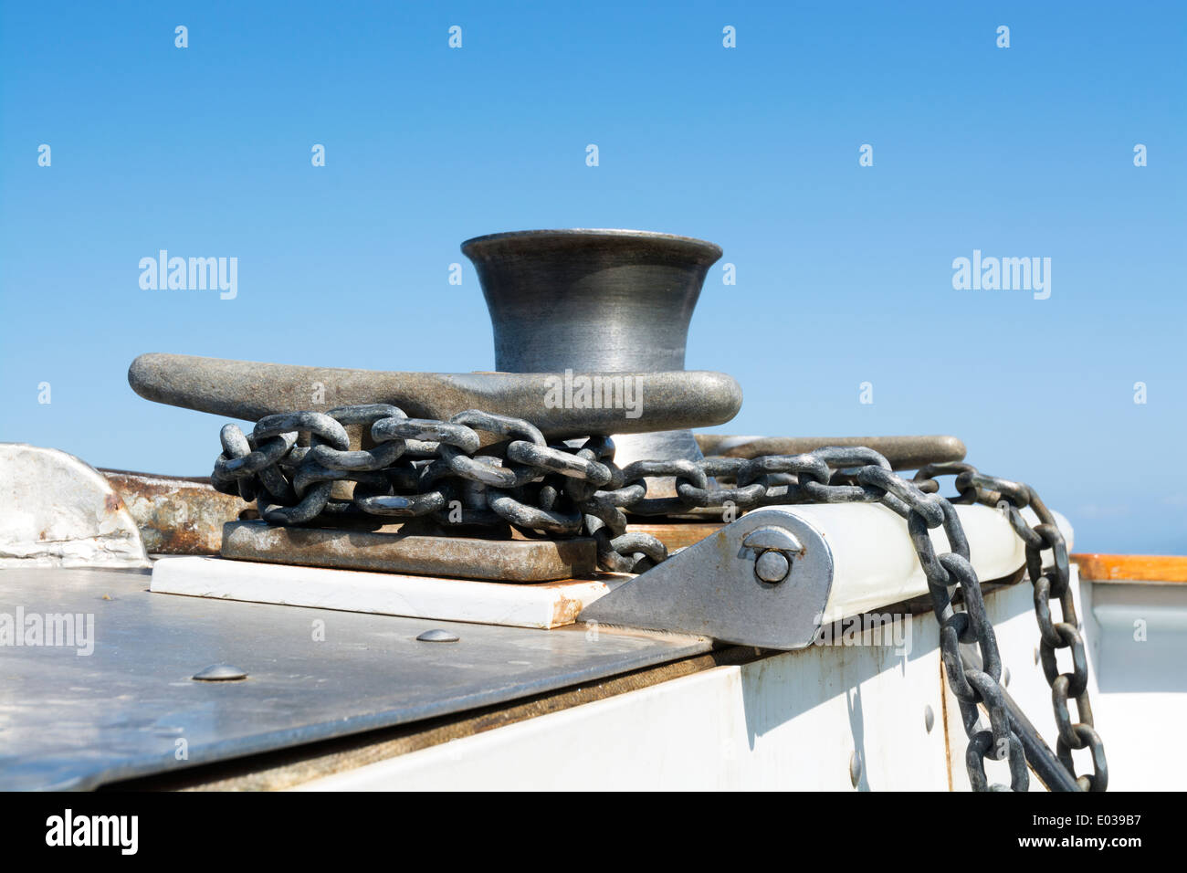 Une chaîne d'ancrage des bateaux est enroulé et fixé autour d'un taquet en acier comme les moteurs de bateau sur l'océan. Banque D'Images