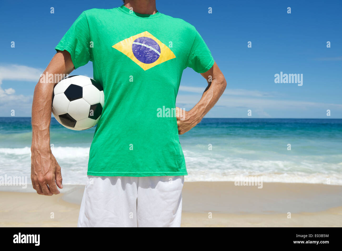 Au Brésil Brazilian soccer player holding football shirt drapeau avec la main sur la hanche de la médecine tropicale et de la plage d'Ipanema Rio de Janeiro Banque D'Images