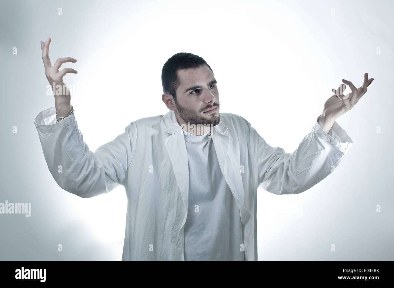 Un jeune chercheur portant un manteau de laboratoire sur fond blanc Banque D'Images