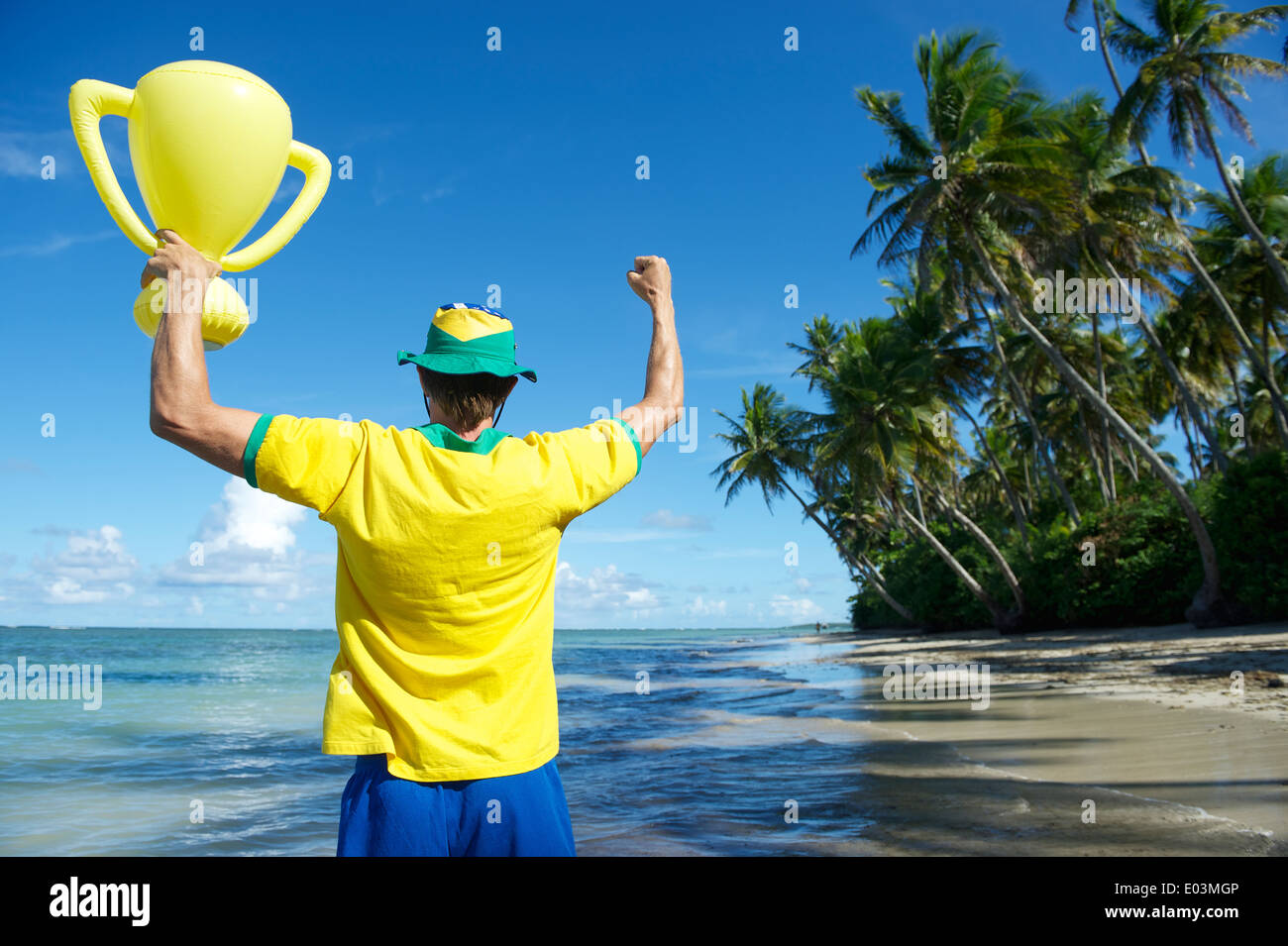 Joueur de football brésilien, l'équipe de couleurs Brésil holding trophy jusqu'à la plage de Nordeste Bahia Banque D'Images
