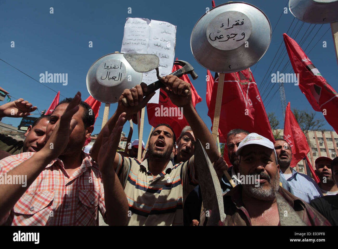 Gaza, la Palestine. 01 mai, 2014. Travaux palestinienne slogans chant comme d'autres l'attente lors d'un des bols mars pour la Journée internationale du travail dans la ville de Gaza, le Jeudi, Mai 1, 2014. L'arabe se lit, ''Le bol de la faim, la pauvreté et la famine, où est la conscience, '' Selon le Bureau des Nations Unies pour la coordination des affaires humanitaires, le taux de chômage dans la bande de Gaza est l'un des plus élevés au monde. Credit : ZUMA Press, Inc./Alamy Live News Banque D'Images