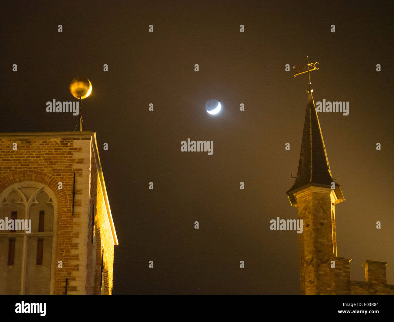 La lune vu entre les bâtiments de la place du marché, du Grote Markt, à Bruges, Belgique Banque D'Images