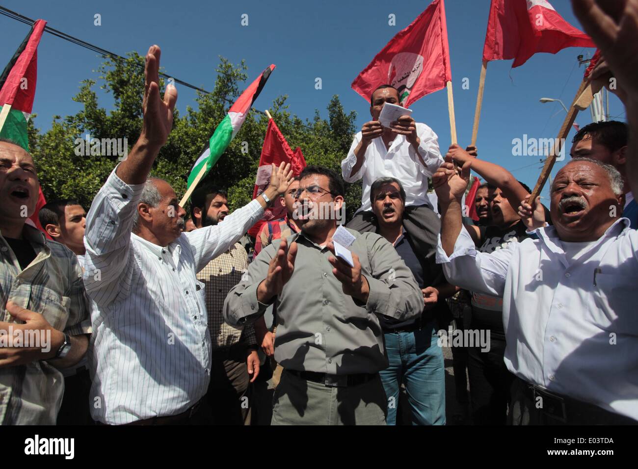 La ville de Gaza, bande de Gaza, territoire palestinien. 1er mai 2014. Travaux palestinienne slogans chant comme d'autres l'attente lors d'un des bols mars pour la Journée internationale du travail dans la ville de Gaza, le Jeudi, Mai 1, 2014. Selon le Bureau des Nations Unies pour la coordination des affaires humanitaires, le taux de chômage dans la bande de Gaza est l'un des plus élevés au monde. Les habitants de Gaza disent que le blocus israélien et égyptien de la répression contre les tunnels de contrebande à la frontière est ce qui les empêchent de gagner leur vie décemment Crédit : Ashraf Amra/APA Images/ZUMAPRESS.com/Alamy Live News Banque D'Images
