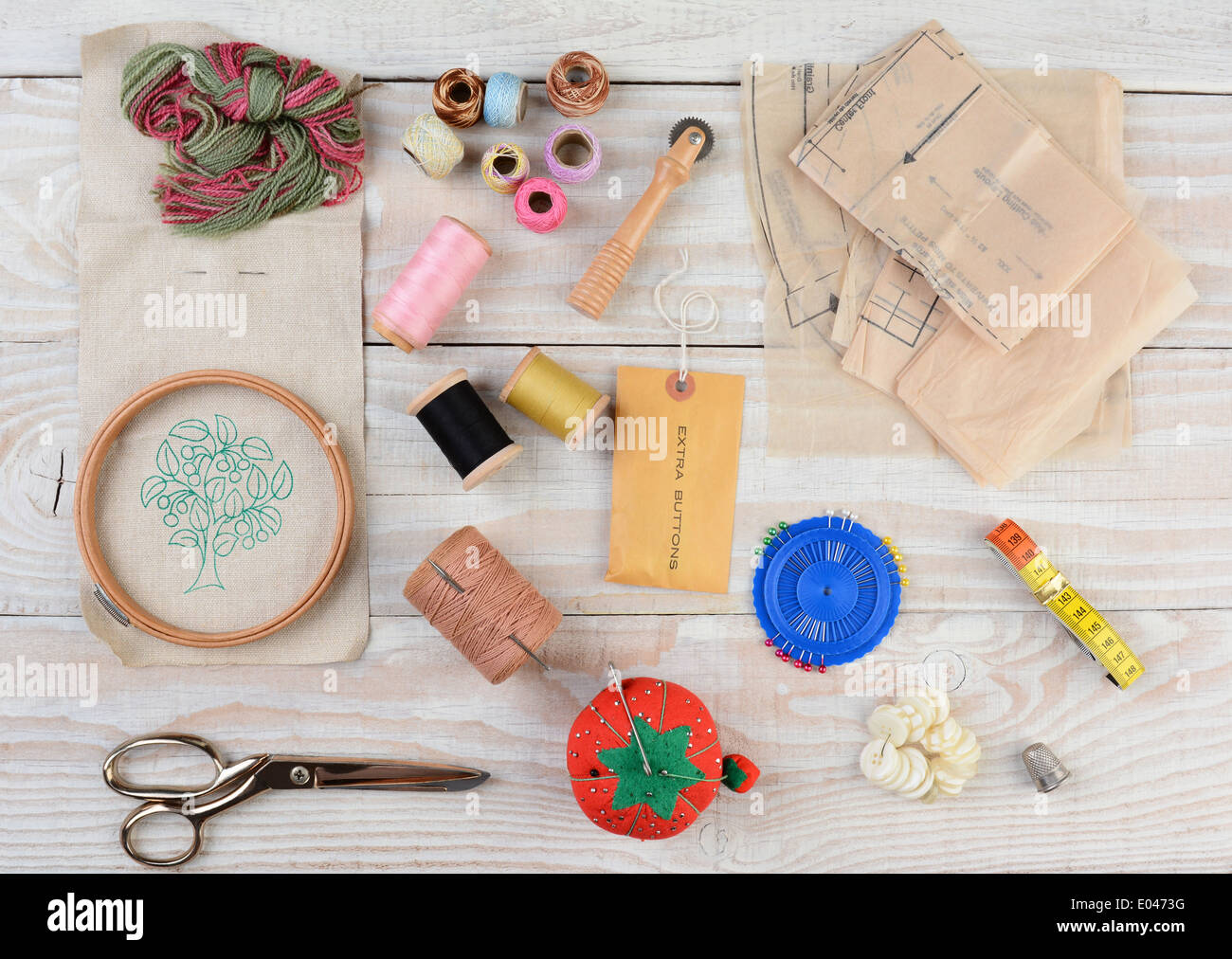 High angle shot d'un assortiment d'outils de couture et de broderie sur un fond de bois rustique. Banque D'Images