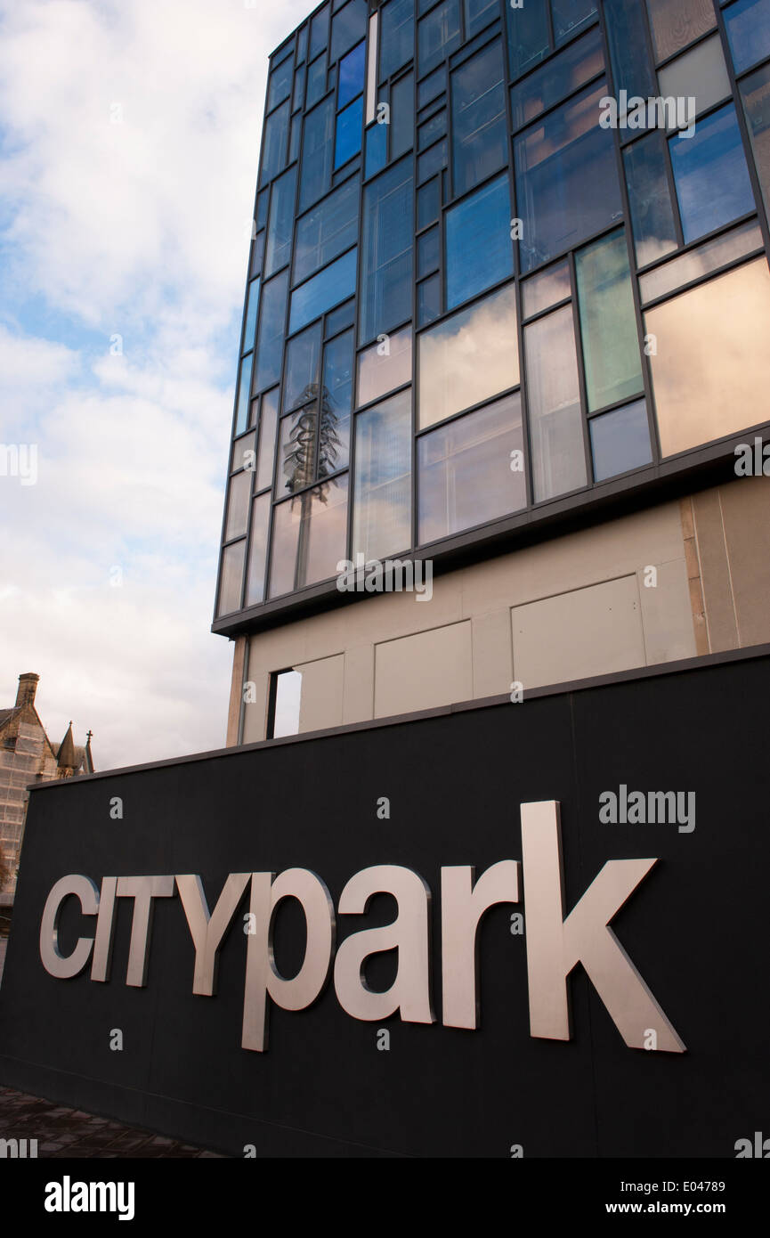 Paysage urbain close-up de grand noir argent Bradford City Park signe avec façade en verre de l'ancien poste de police, derrière - West Yorkshire, Angleterre, Royaume-Uni. Banque D'Images