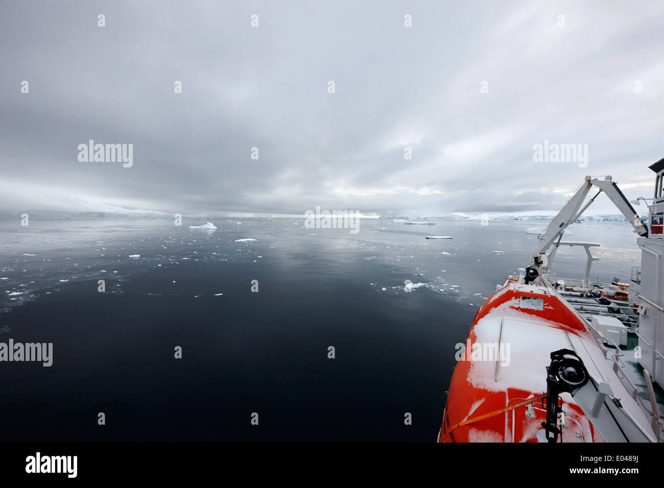 Navire d'expédition avec un canot de sauvetage couvertes de neige mouillée dans la baie sur l'Île Anvers Fournier l'Antarctique Banque D'Images