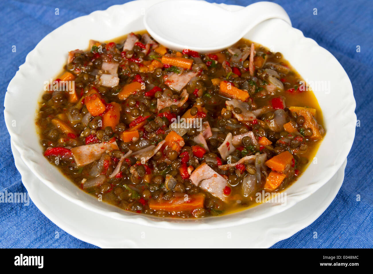 Petit bol de soupe faite avec les lentilles beluga, carottes, poivrons et jambon Banque D'Images