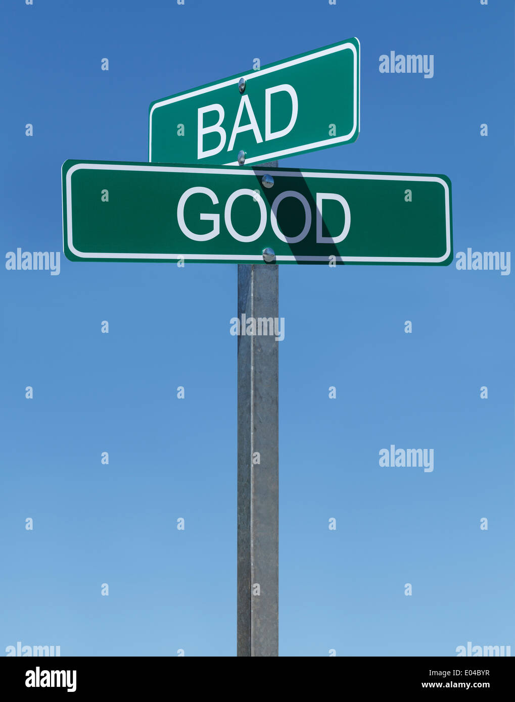 Deux plaques de rue vert Bon et mauvais sur poteau avec fond de ciel bleu. Banque D'Images