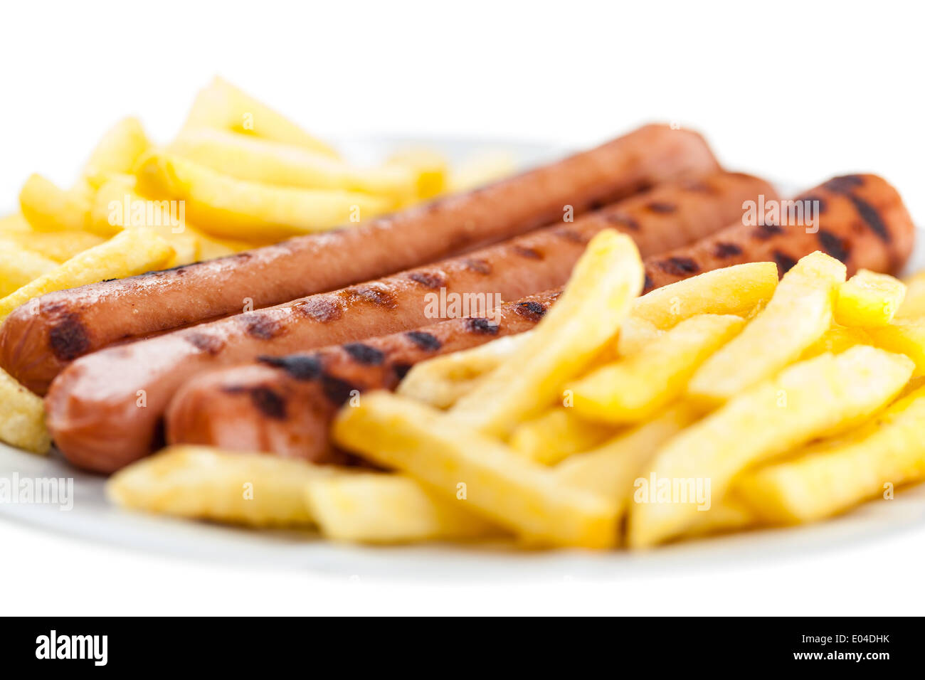 Trois délicieux wurstel sur une plaque blanche avec frites Banque D'Images