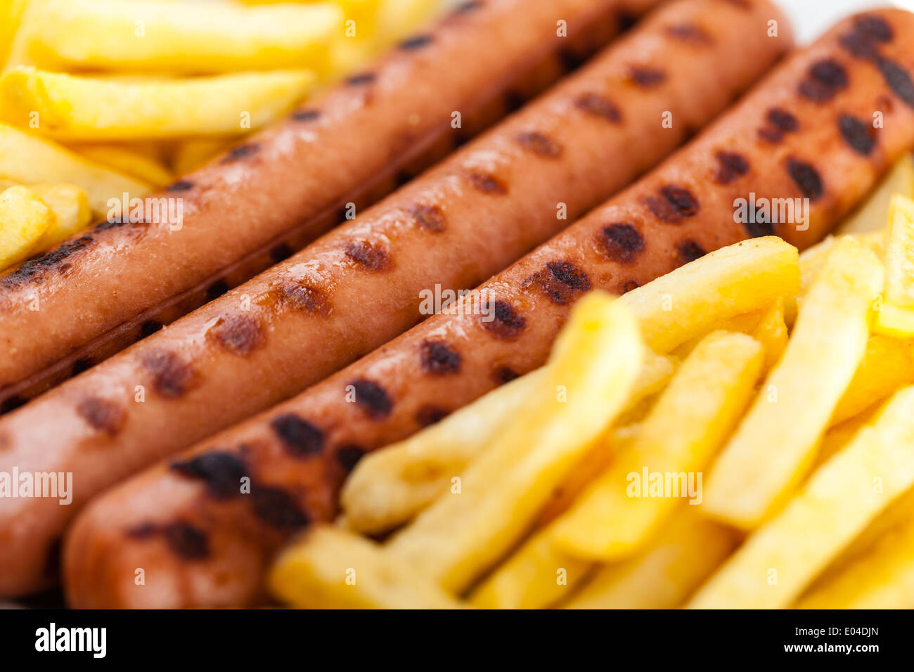 Trois délicieux wurstel sur une plaque blanche avec frites Banque D'Images