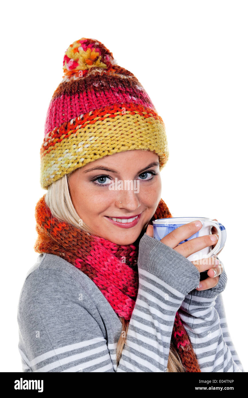 Jeune femme avec net pièce réchauffe elle-même avec du thé chaud., Junge Frau mit sich mit Haube waermt heissem Tee. Banque D'Images