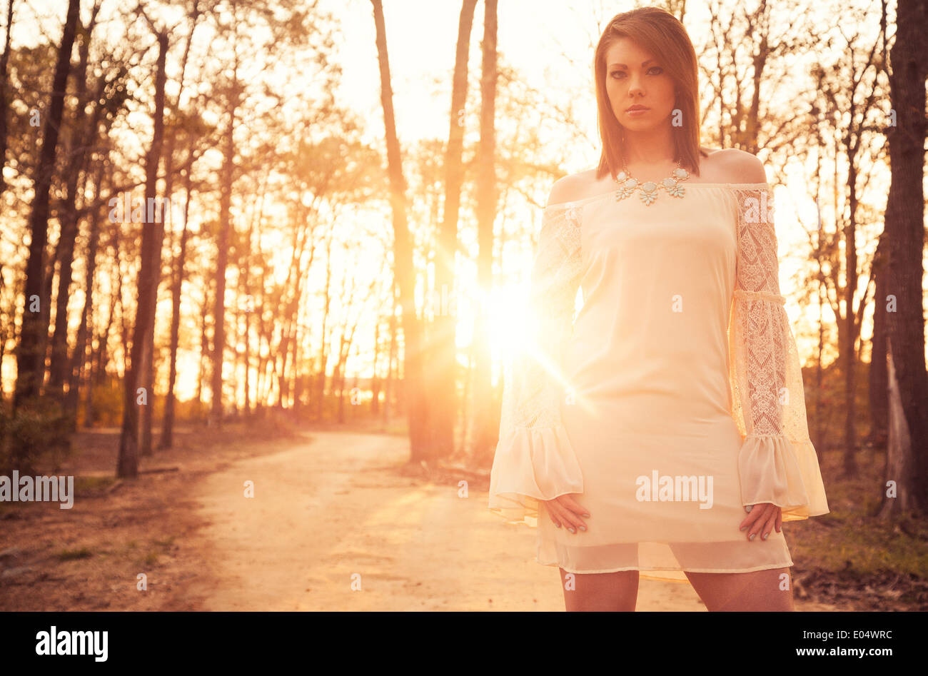 Jeune femme en robe blanche au lever du soleil Banque D'Images