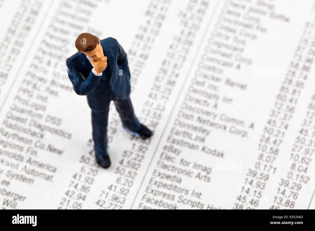 Une petite figure et les cours d'actions dans un journal. Gagner de l'argent à la bourse. Les profits et les pertes en matière de commerce., E Banque D'Images