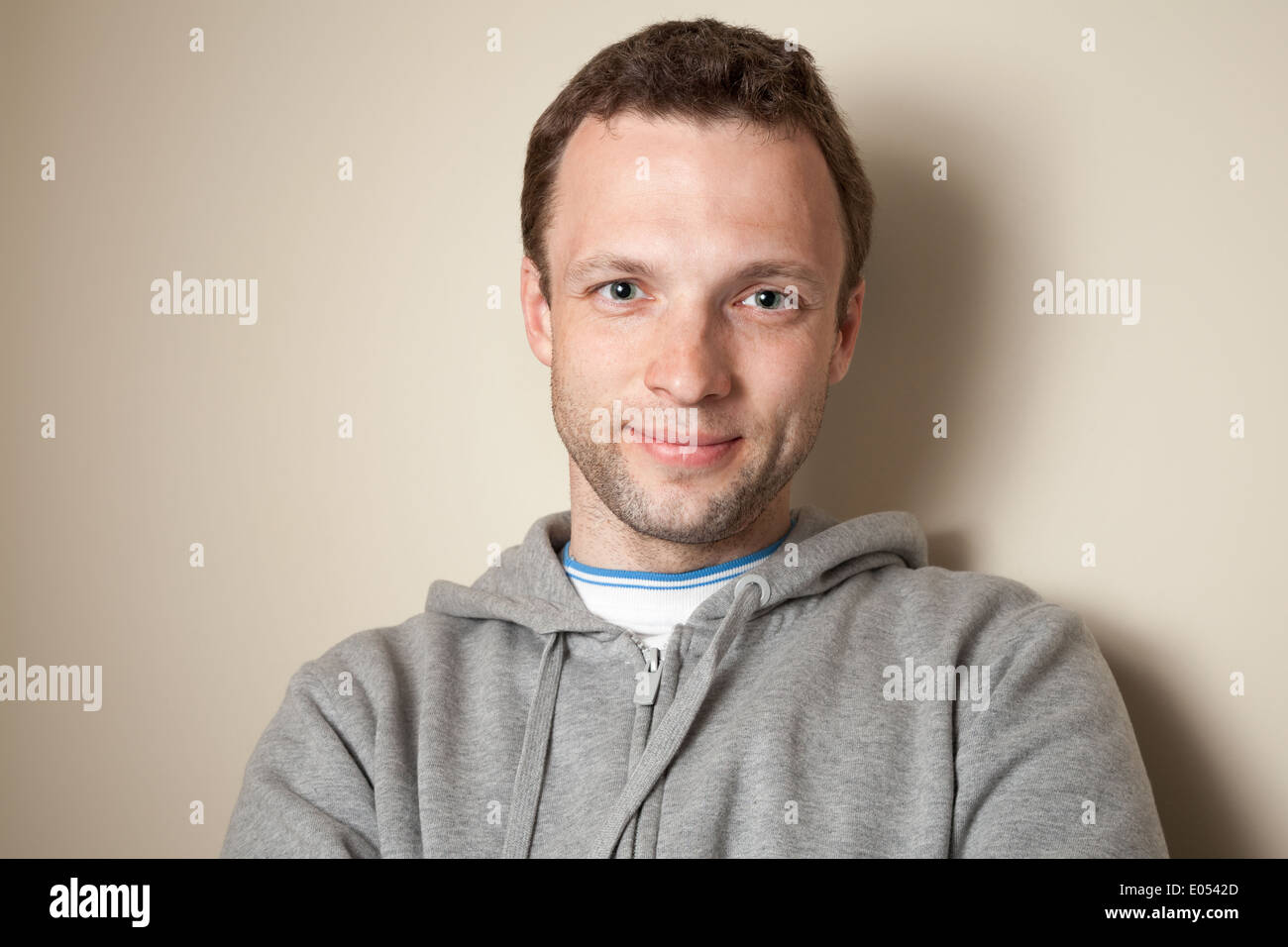 Young smiling Caucasian man en gris avec capuche veste de sport Banque D'Images