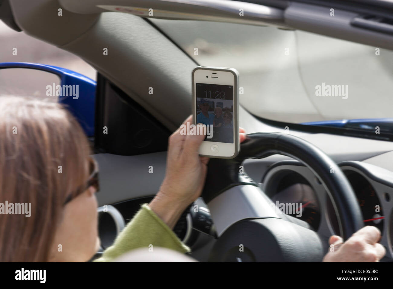 Femme mature La messagerie texte au volant d'un voiture de sport, USA Banque D'Images