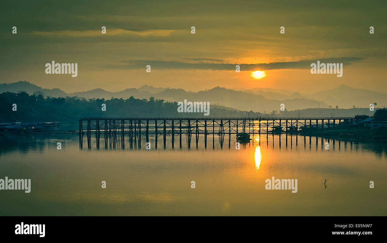 Le soleil se lève le matin derrière la destoyed pont en bois. Banque D'Images