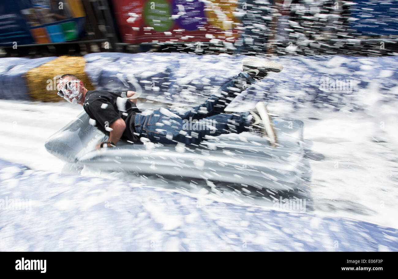 Bristol, Royaume-Uni. 04 mai, 2014. Les gens vers le bas de la vitesse d'un toboggan de 90m érigée sur la rue Park à Bristol. Luke Jerram artiste a organisé l'événement où 300 personnes va dévaler des feuilles de plastique trempé dans du liquide vaisselle et bordée de 400 balles de foin. 4 mai 2014 Crédit : Adam Gasson/Alamy Live News Banque D'Images