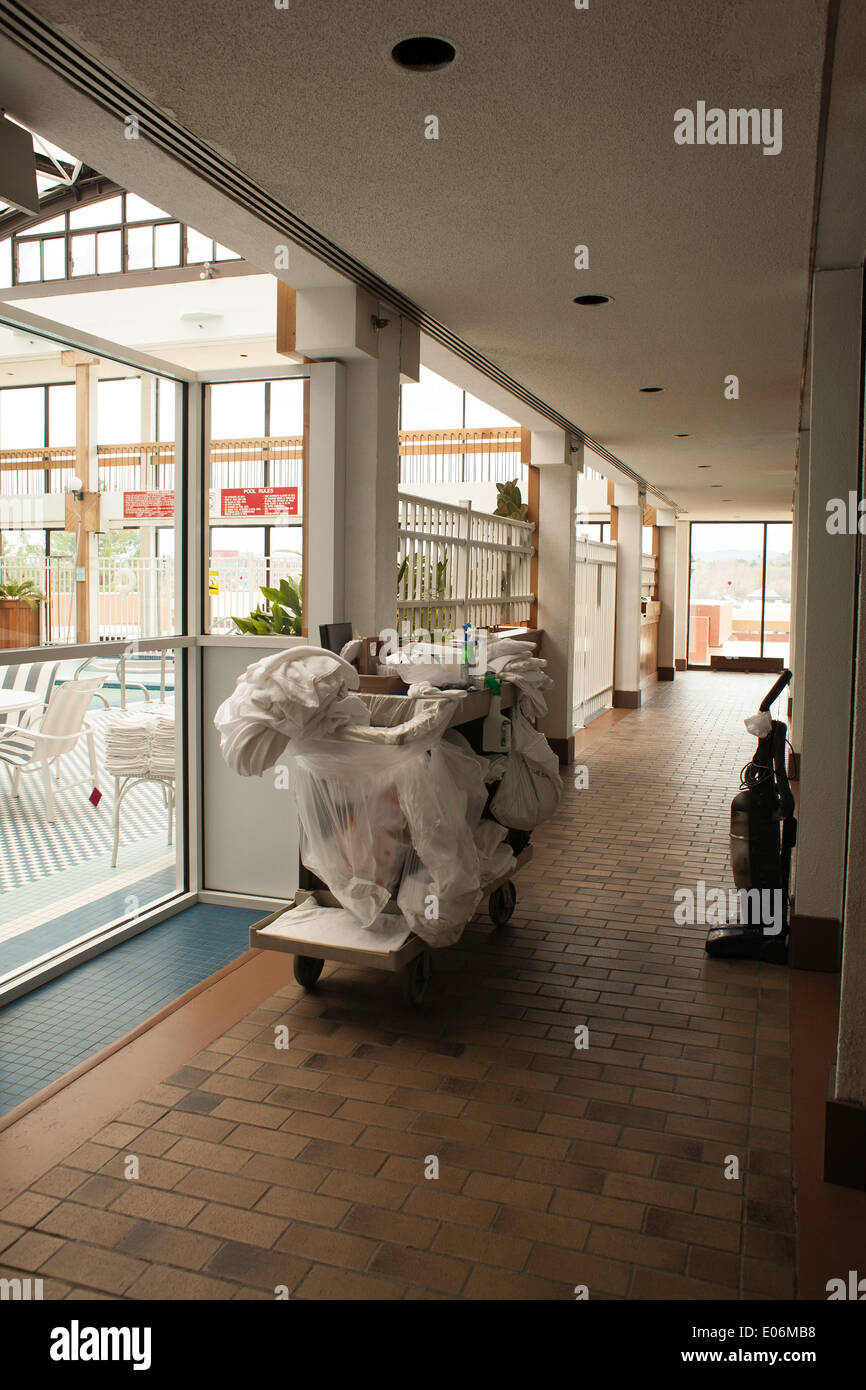 Panier à linge sale et attend à l'extérieur de nettoyage prix dans un hôtel de la Nouvelle Angleterre. Au-delà de la piscine portes en verre. Banque D'Images