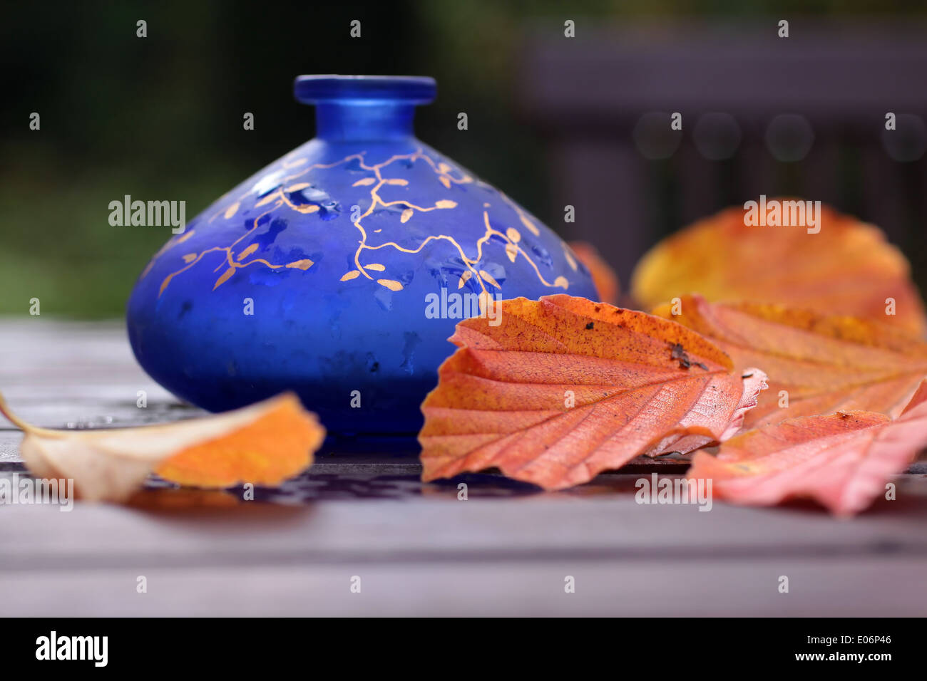 Vase bleu avec décoration d'automne sur une table en bois Banque D'Images