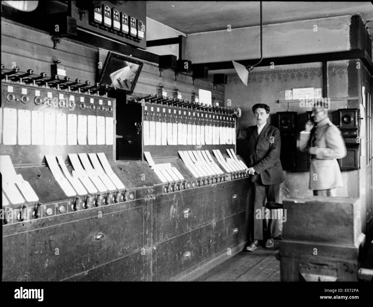 Cette image historique capture les cheminots dans la salle de contrôle des signaux de la gare de Bingerbrück, située en Rhénanie-Palatinat, en Allemagne. La gare a joué un rôle crucial dans les opérations ferroviaires régionales, les travailleurs gérant le trafic et la sécurité des trains. L'image fait partie de la collection de la Bibliothèque de Toulouse, reflétant les progrès technologiques dans les systèmes ferroviaires à l'époque. Banque D'Images