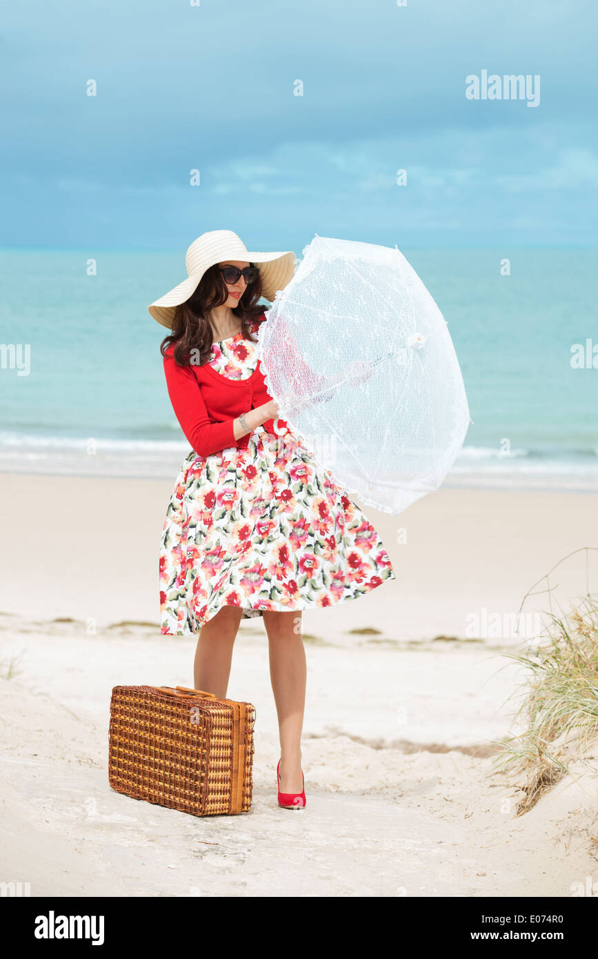 Belle dame en rouge traveler en robe de style rétro sur la plage Banque D'Images