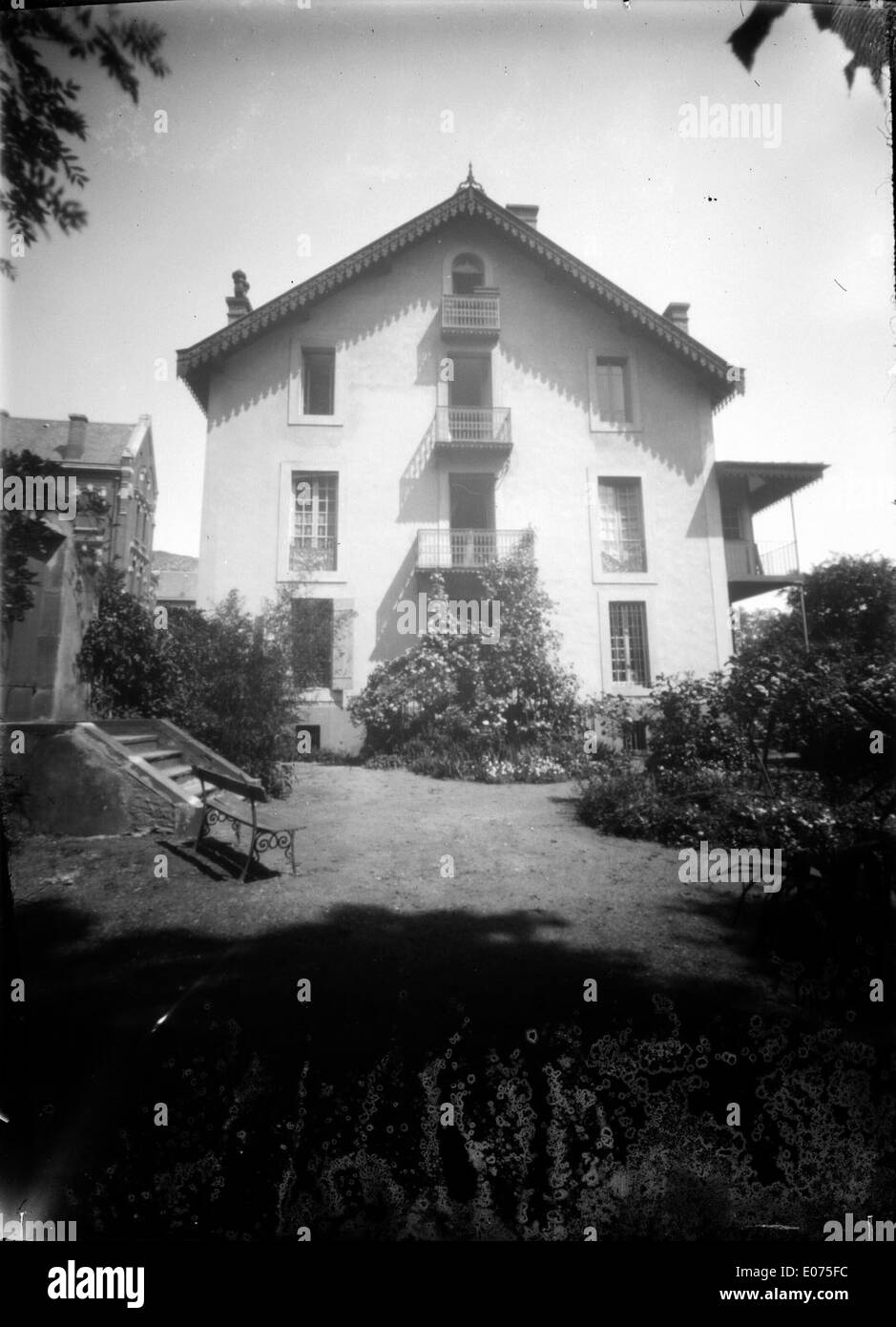 Cette aquarelle de Trutat de 1907 intitulée 'notre chalet' représente un chalet pittoresque entouré de roses en fleurs et de verdure luxuriante à Foix. La peinture capture la sérénité de la vie rurale française avec un feuillage vibrant et une vie végétale délicate. Banque D'Images