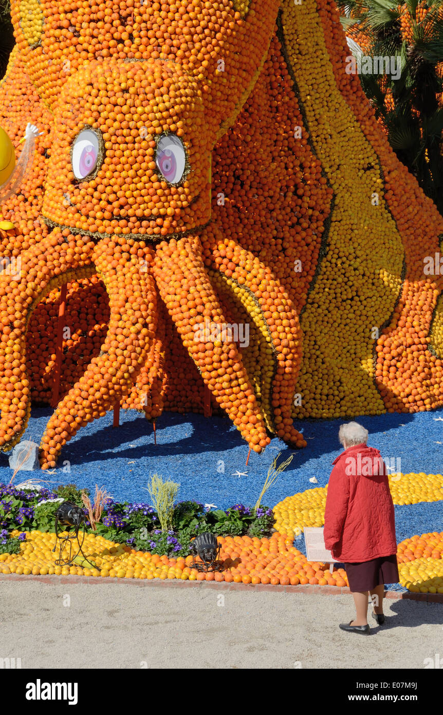 Visiteur de la fête du citron à Menton admire une sculpture d'Orange d'une pieuvre géante Alpes-Maritimes France Banque D'Images
