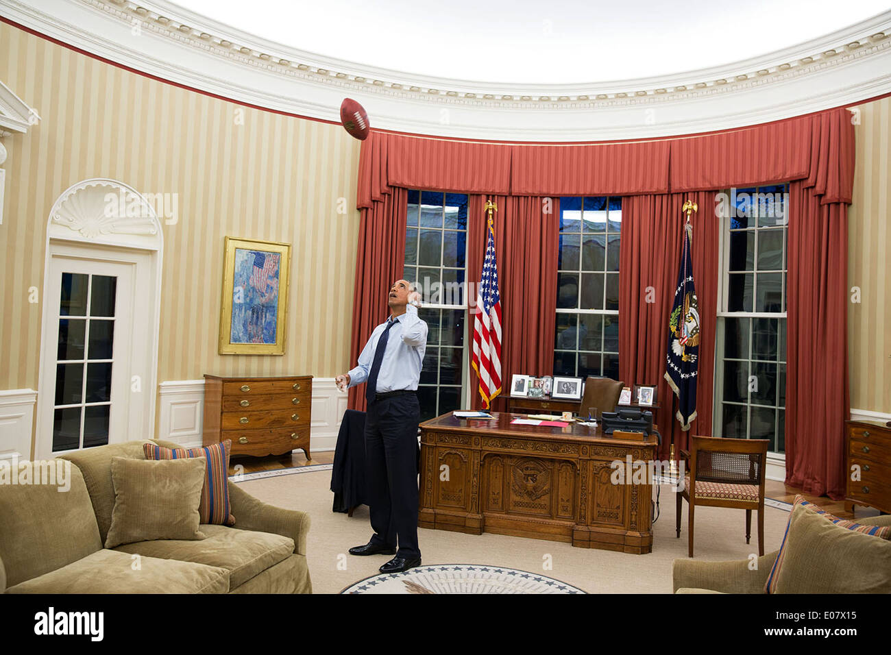 Le président américain Barack Obama lance un football dans le bureau ovale de la Maison Blanche le 6 janvier 2014 à Washington, DC. Banque D'Images