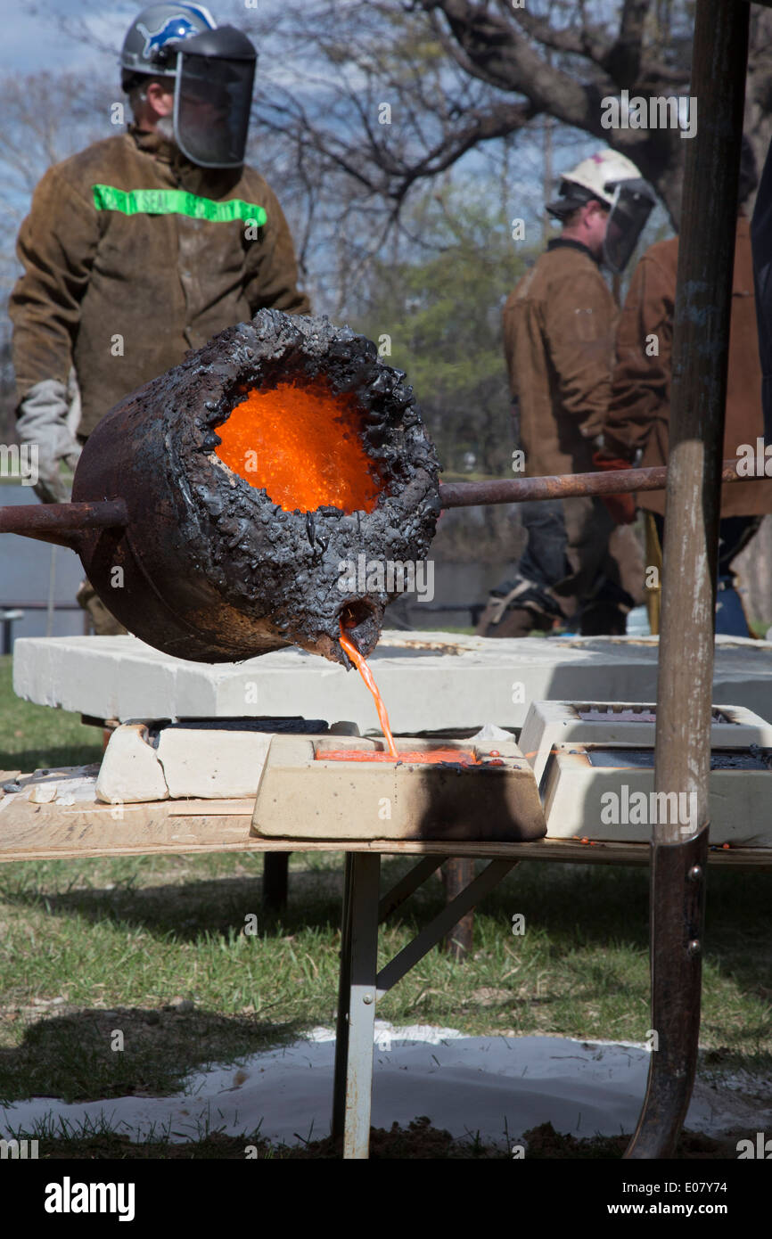 Detroit, Michigan - Les membres de la fondation pour l'éducation à but non lucratif des arts de faire fondre le fer et le verser dans des moules à une foire d'art. Banque D'Images