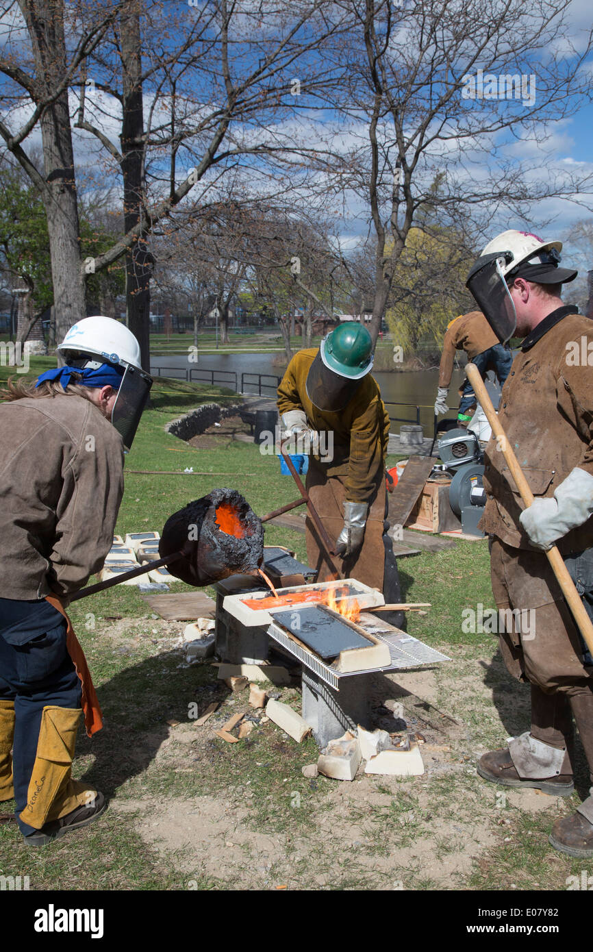 Detroit, Michigan - Les membres de la fondation pour l'éducation à but non lucratif des arts de faire fondre le fer et le verser dans des moules à une foire d'art. Banque D'Images