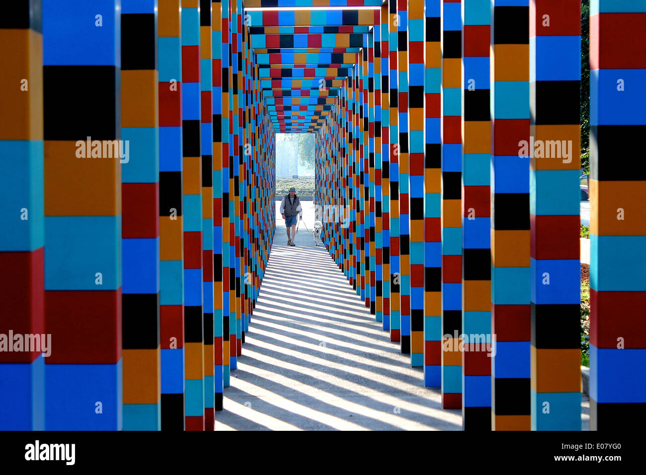 Homme et chien marchant dans une pergola colorée avec des lignes géométriques et des ombres, Polanco, Mexico Banque D'Images