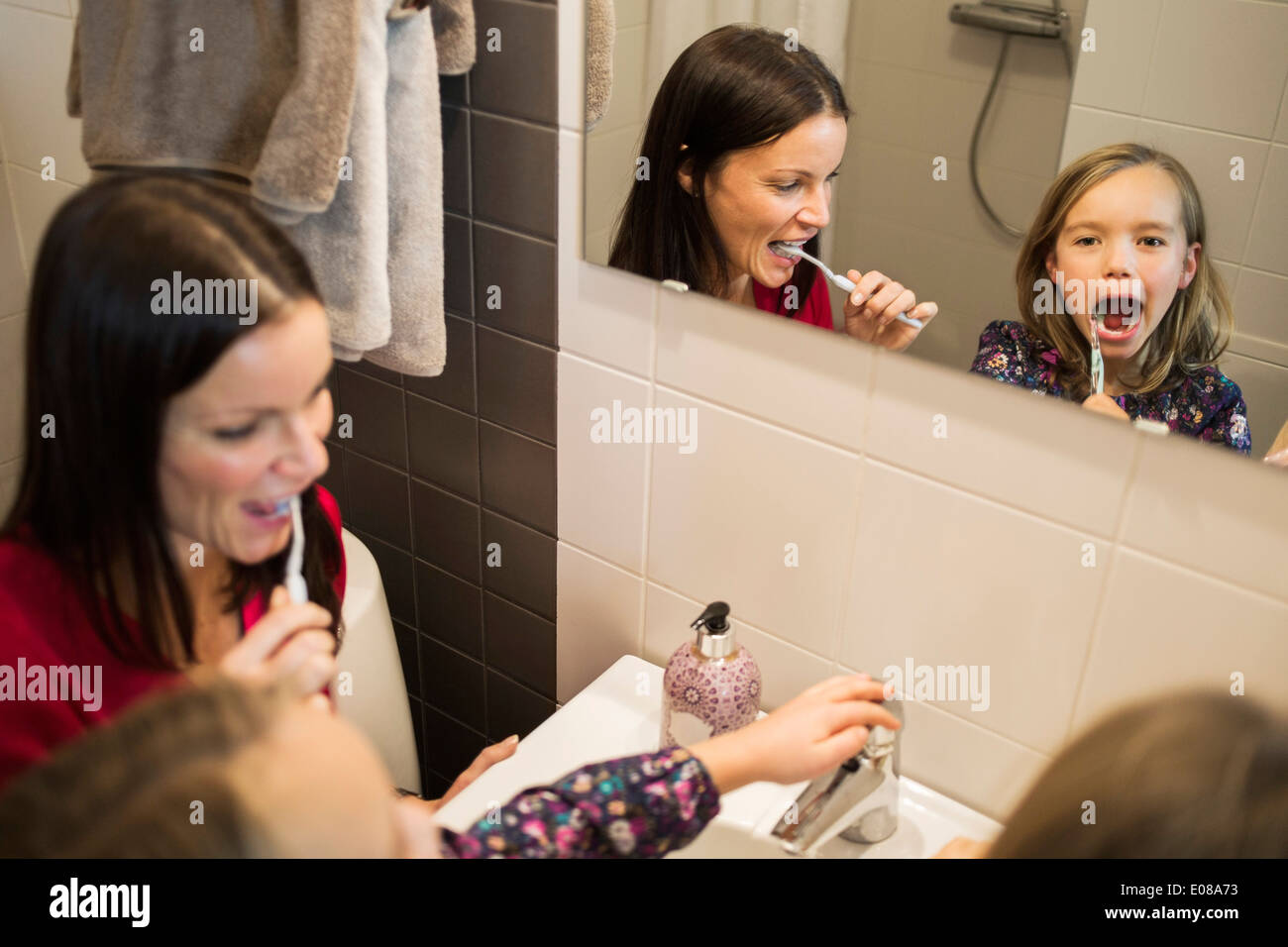 Mère et fille se brosser les dents dans la salle de bains Banque D'Images