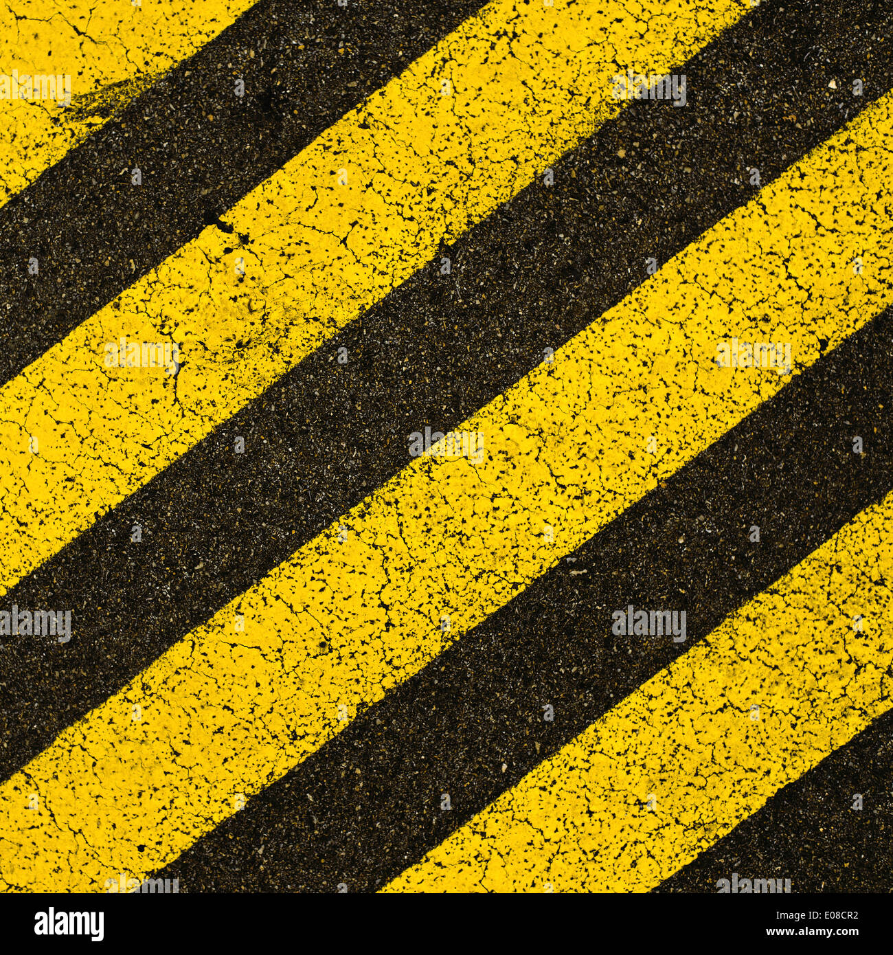 Rayé jaune marquage routier sur la route d'asphalte noir. Il est interdit de stationner sur l'espace couvert de cette stripes. Banque D'Images